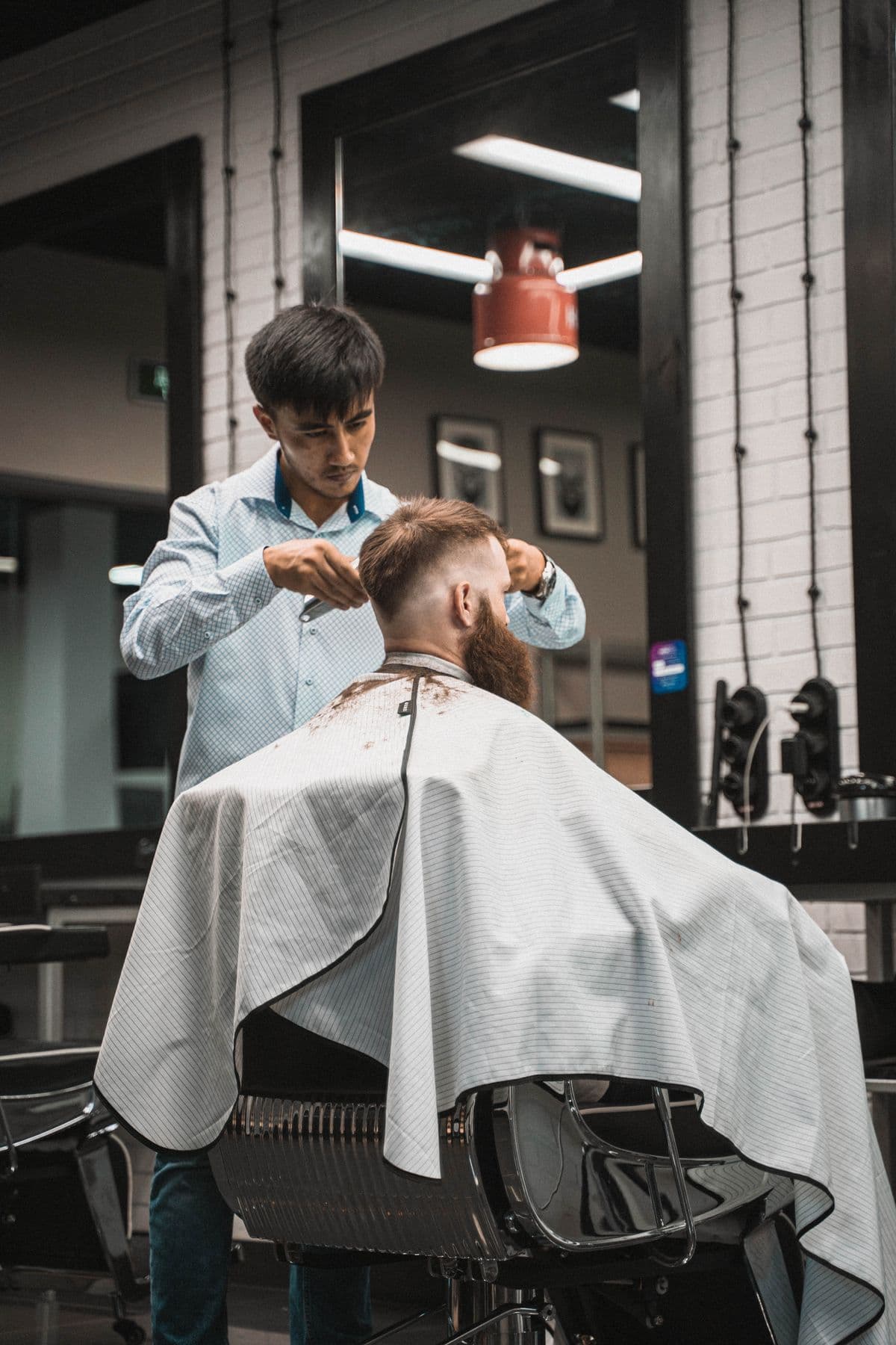 A barber working with a client in a barbershop